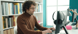 A translator working at a computer, surrounded by reference books, showcasing the crucial role of human translators.
