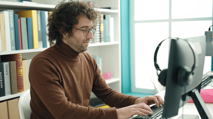 A translator working at a computer, surrounded by reference books, showcasing the crucial role of human translators.